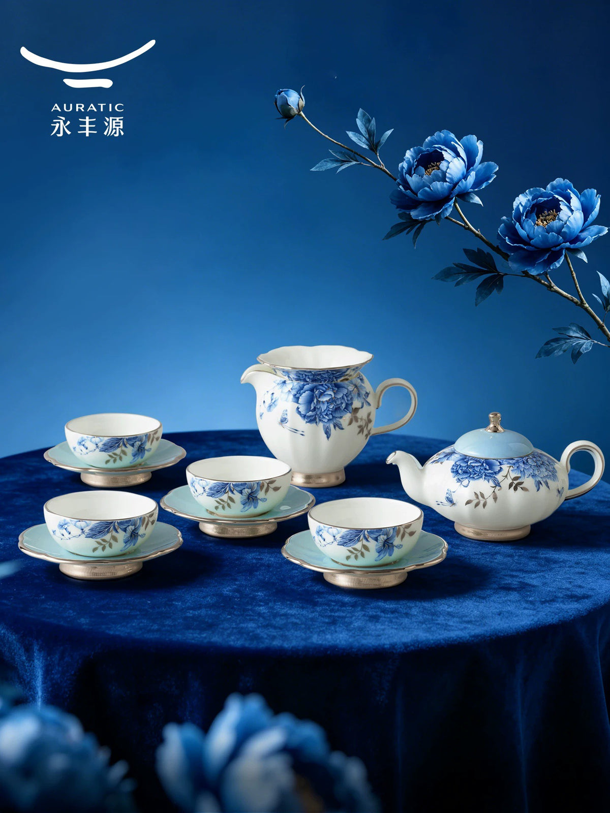 Blue-and-white peony tea set with teapot, fair cup and four teacups on sky-blue saucers, styled on a navy table